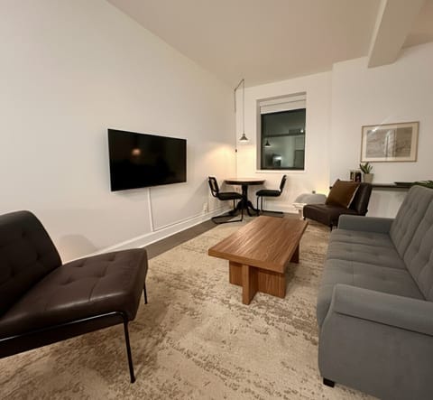 Spacious living area with sofa bed, abundant natural light, and city skyline views