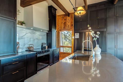 Chef's kitchen with large capacity range and 62" refrigerator.