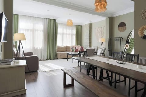 Cover: Our spacious living room with sofas and a huge dining table.