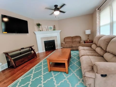 Living Room with reclining sofa and loveseat, coffee table top raises for dining