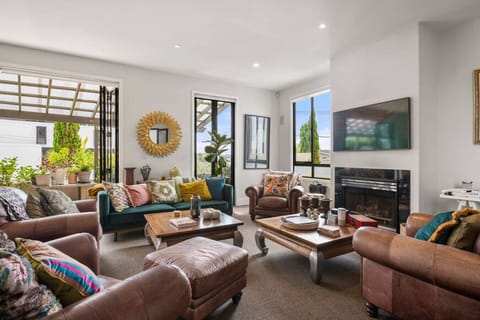 Open plan kitchen, dining and living, complete with cosy couches, and views over the harbour and sky tower