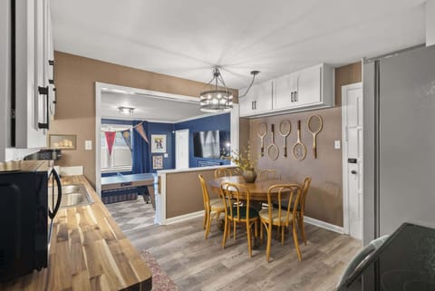 Open dining area w/ wooden table, statement lighting & easy flow to the kitchen for shared meals.