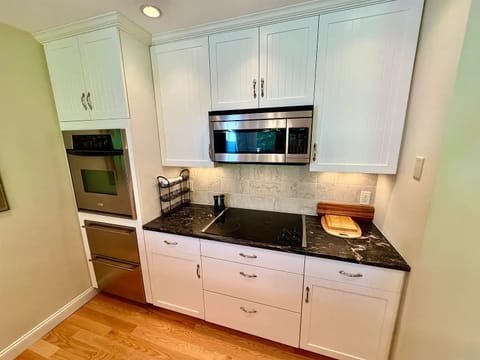 Kitchen view of refrigerator drawers, oven, electric stove top, microwave