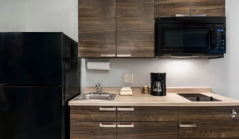 Brew coffee and prep snacks with fridge, microwave, and cooktop