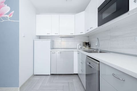 Contemporary kitchen with white cabinets and modern equipment.