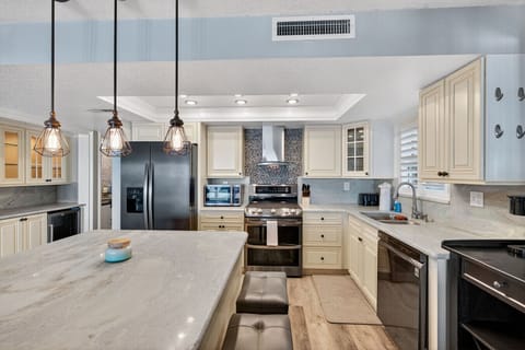 Spacious kitchen w/ island seating & modern finishes, great for cooking & gathering together.