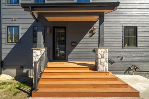 Warm wood steps lead to a modern mountain entryway.