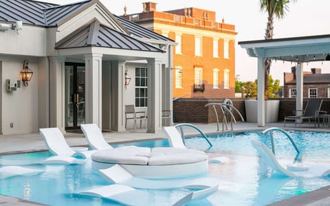 Outdoor pool with lounge chairs and shaded seating areas