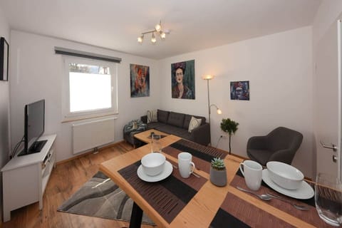 Wohnzimmer mit Essbereich, TV und Roku-Streaming.
