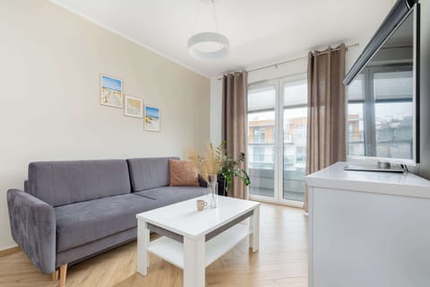 Bright living room with a cozy sofa and access to a private balcony, perfect for relaxing after a day of sightseeing.
