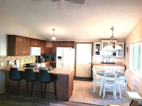 DINING AREA AND KITCHEN: Looking into the dining area and kitchen from the living room. (The door shown is the front entrance to the house.)