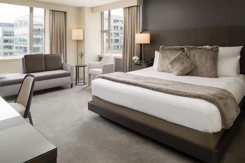 Drift off in a serene king bed with city light.