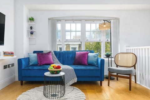 Bright open-plan Shoreditch apartment with modern kitchen, cozy sofa, and large windows — your stylish home in London’s creative heart.
