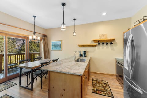 The full kitchen features granite countertops, stainless steel appliances, and breakfast bar.