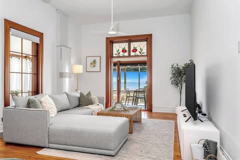 Relax in the ocean-view living area, where an L-shaped sofa, large-screen TV, and natural light create a serene front-row seat to Henley’s horizon.
