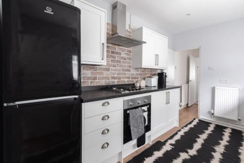 Modern kitchen with oven, hob, and black fridge freezer