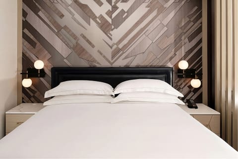 Sink into crisp linens beneath a stylish, modern headboard.