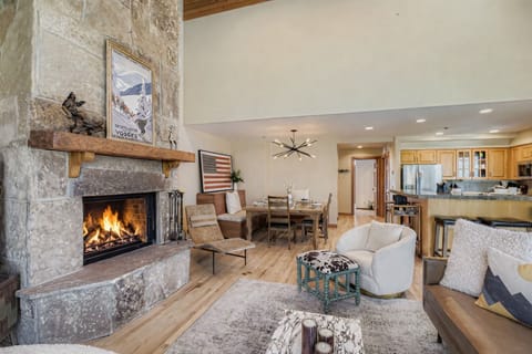 Escape to a cozy, rustic retreat! Enjoy this charming mountain living room featuring a stone fireplace, natural wood beams, and comfortable seating.