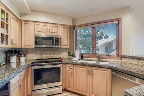 Cook in a gourmet rustic kitchen! Featuring stunning granite countertops, high-end stainless steel appliances, custom knotty-wood cabinetry, and unique bear-themed bar stools.