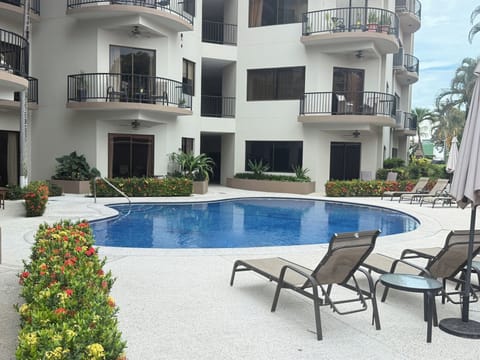 Peaceful pool area with loungers and lush landscaping