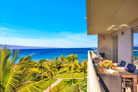 Lounge on the private lanai with sweeping blue-water views framed by tropical greenery. HKH-504