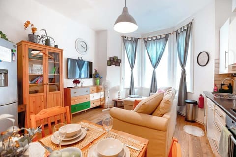 good size living room with sofa, tv, dining table and kitchen