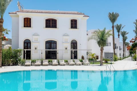 Arrive to elegant villas opening onto a sparkling blue pool.
