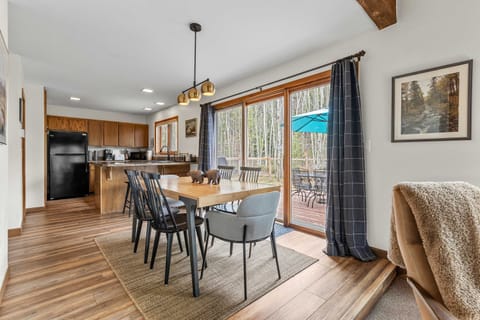 Open-concept dining area seating 6 with forest views for memorable meals.