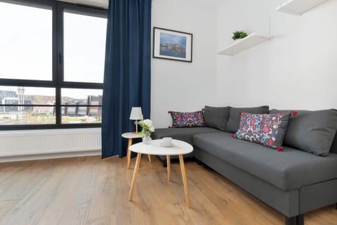 A large window overlooking the surroundings fills the living room with light, enhancing its modern design and sense of space.

