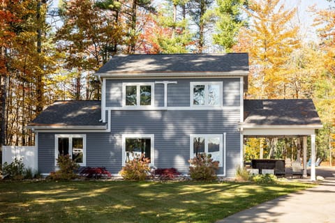 This spacious two-story home features a covered carport with hot tub, landscaped gardens, and a peaceful wooded setting perfect for fall getaways