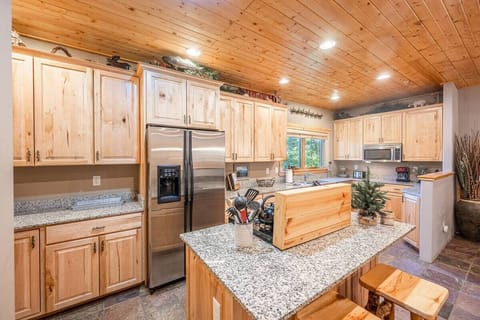 The large kitchen is fully equipped and includes a kitchen island with bar seating.