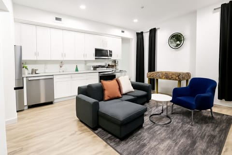 Unwind after a long day of exploring in this bright, modern living room comfy seating, smart TV, and warm lighting create the perfect chill spot.
