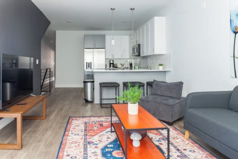 Step into our inviting living room, where a plush sectional couch beckons for relaxation after a day of exploration. The entertainment center boasts a state-of-the-art smart TV for your viewing pleasure #WelcomingSpace #ColorfulVibes