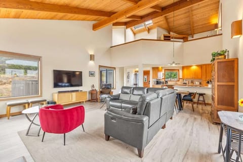 Spacious living room with vaulted ceilings, ocean views, and a cozy fireplace.