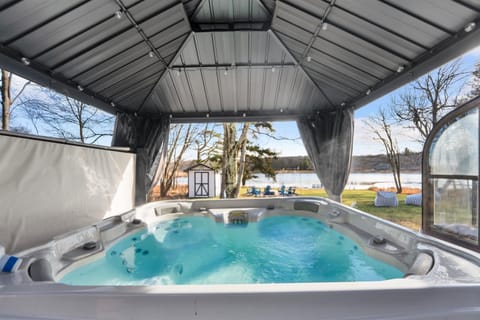 Covered hot tub overlooking the lake — soak anytime