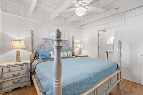 Spacious master bedroom featuring a plush king bed with fresh linens, soft lighting, and coastal décor—perfect for unwinding after a day at the beach at 506 Miller Lane in North Myrtle Beach