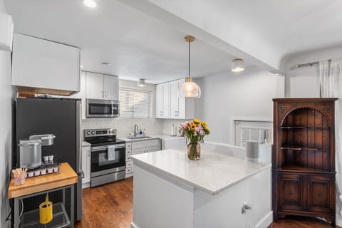 Step into your bright, fully-equipped kitchen where you'll love preparing meals on gleaming countertops. The spacious island becomes your morning coffee spot as warm light filters through windows.
