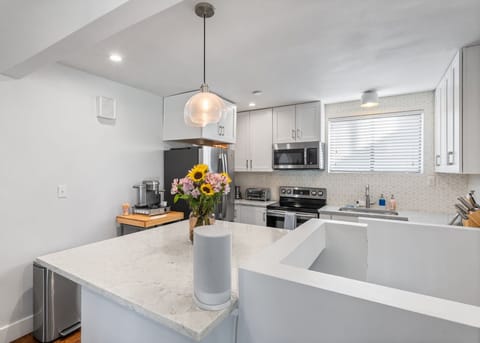 Step into your bright, modern kitchen where sunflowers greet you from marble countertops. You'll love preparing meals with premium appliances and plenty of counter space, all bathed in natural light.