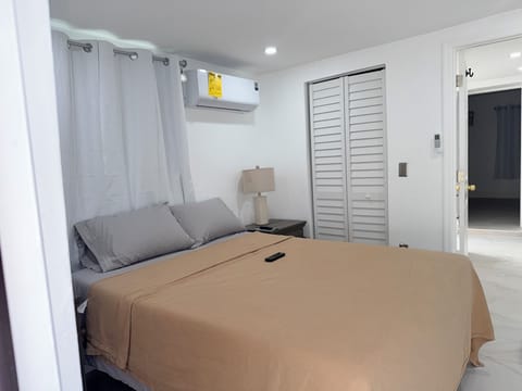 Step into your serene bedroom retreat where crisp white walls and soft gray linens create the perfect atmosphere for restful nights. Cool air conditioning keeps you comfortable while modern amenities surround you.