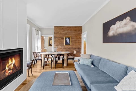 An open-concept living and dining space welcomes you with a gas fireplace, designer furnishings, and an inviting coastal ambiance.