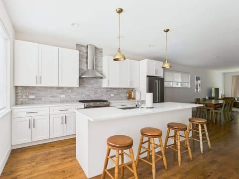 Bright, fully equipped chef’s kitchen featuring quartz counters, brass accents, and everything you need to cook or entertain.