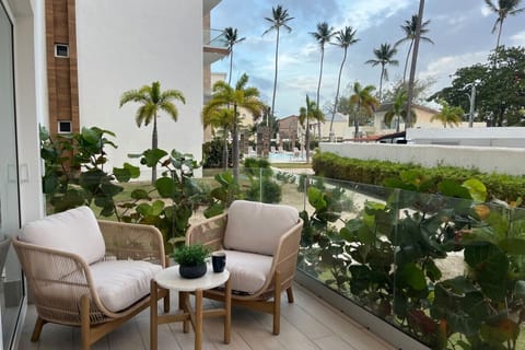 Private ground-floor terrace with two lounge chairs and a side table, opening off the living room.