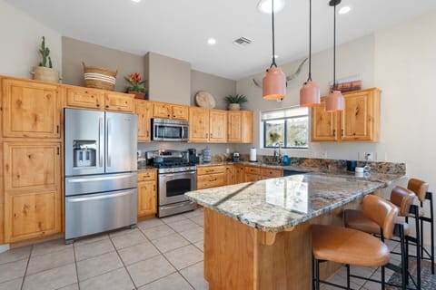 Full kitchen: Keurig, dishwasher, microwave, range, fridge, bar seating.