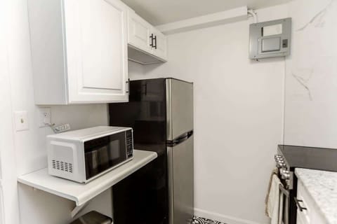 Kitchen with microwave, full fridge, and oven. 