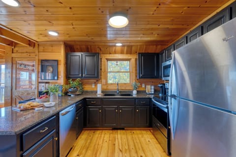 Fully equipped kitchen with granite counters, stainless steel appliances, and bar seating for easy vacation cooking.