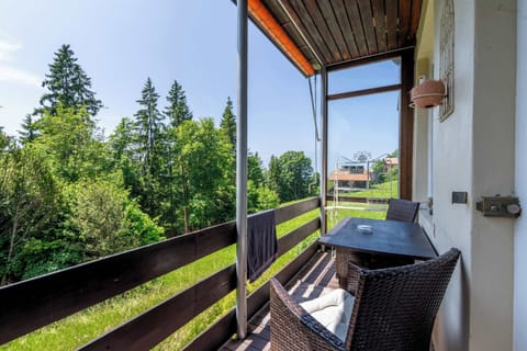 Private balcony with outdoor seating and green surroundings