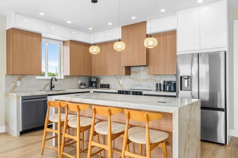 Sleek modern kitchen with waterfall island, stainless appliances, and seating for the whole crew.