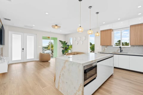 Gourmet kitchen with marble island and open concept living, ideal for gathering with family while preparing fresh Keys seafood feasts.