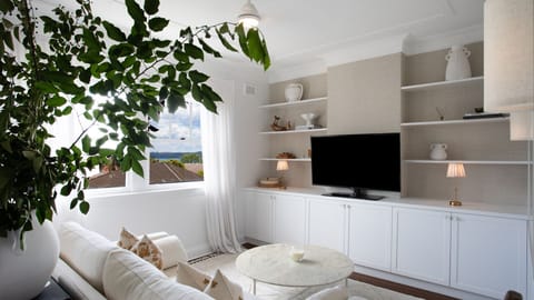 Bright living space – Sun-filled lounge with elegant décor and lush indoor greenery.