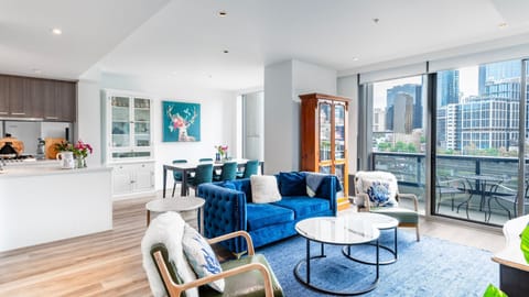 Bright open-plan living area with floor-to-ceiling windows and balcony access